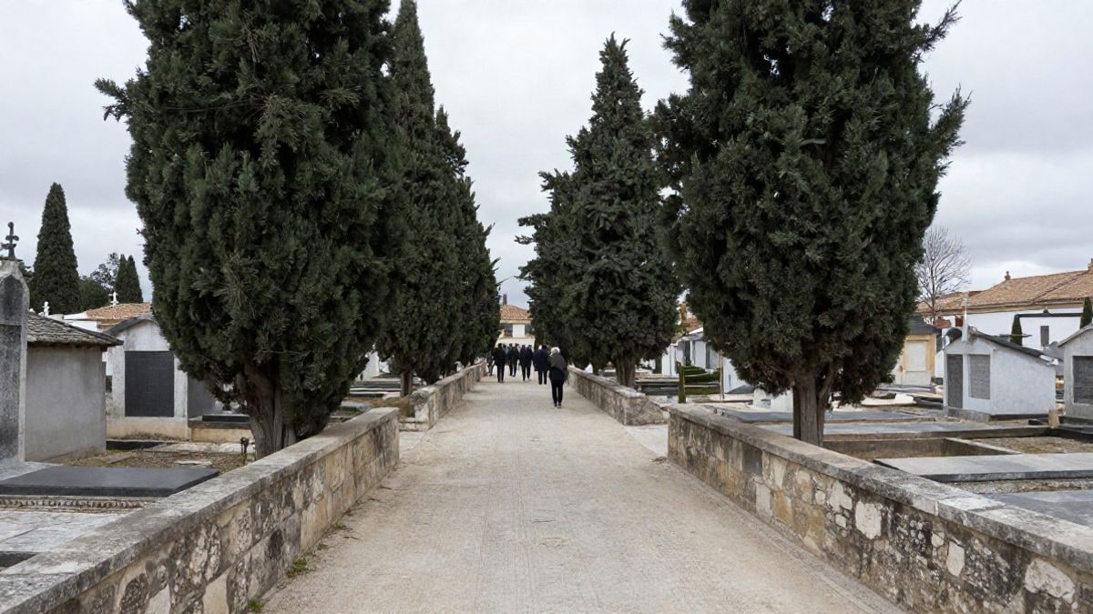 Imagen ilustrativa: un cementerio viejo con cipreses y muros de piedra, con algunas personas de espaldas en la distancia