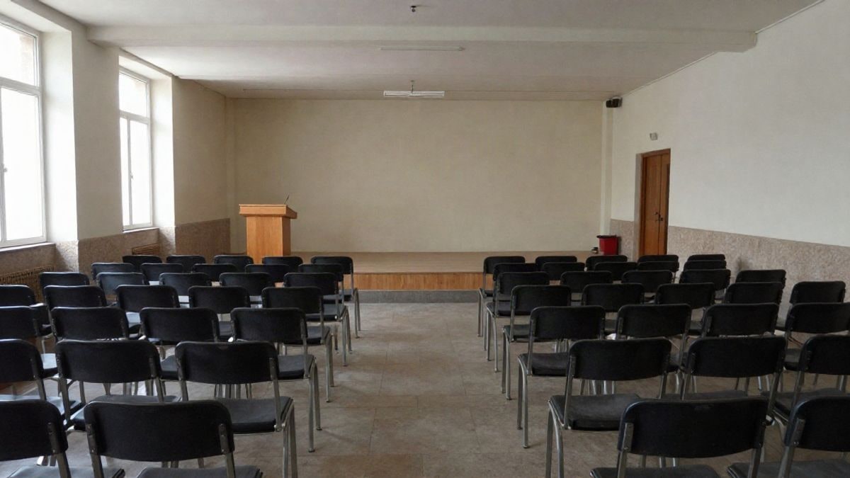 Imagen ilustrativa: filas de sillas vacías en una sala pública orientadas hacia un atril