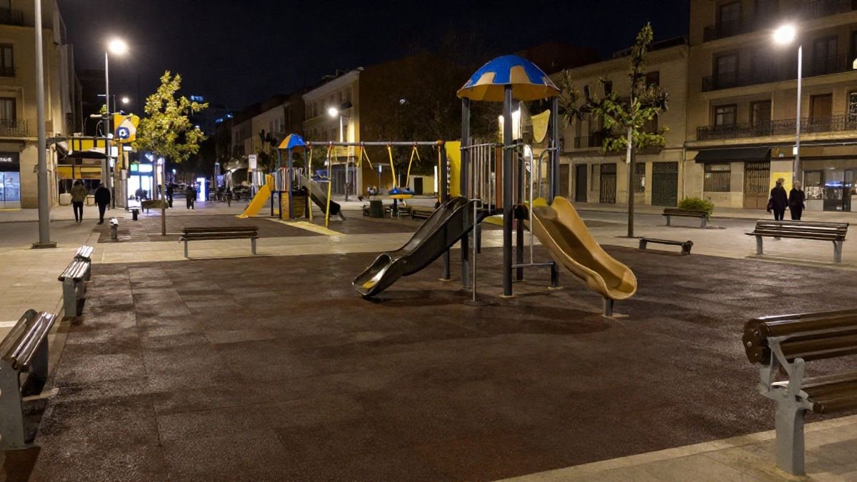 Imagen ilustrativa: plaza urbana de noche con juegos infantiles y farolas encendidas