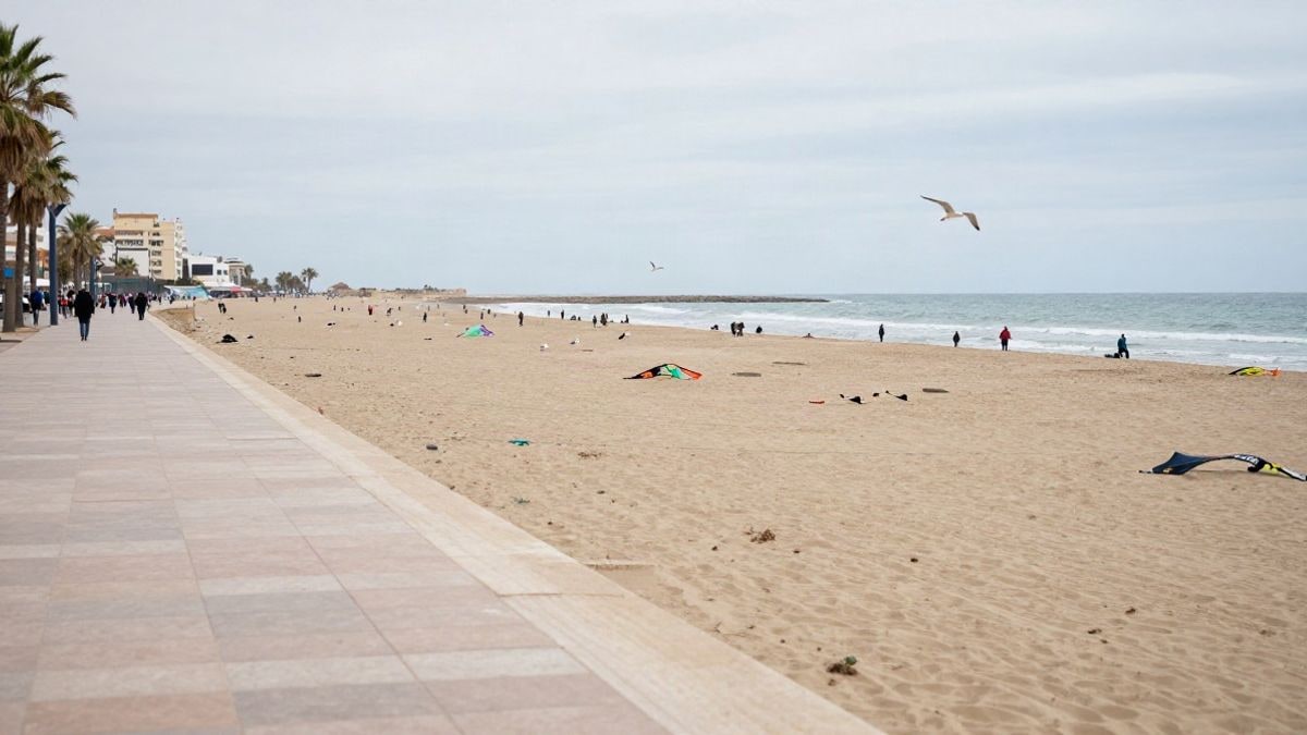Imagen ilustrativa: playa urbana en un día nublado con cometas en la arena