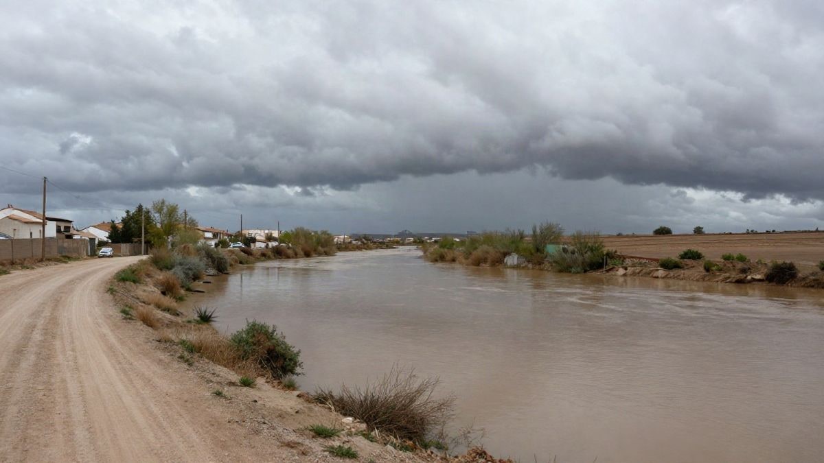 Imagen ilustrativa: lecho de ria seca en un paisaje mediterráneo con nubes de tormenta y charcos de agua