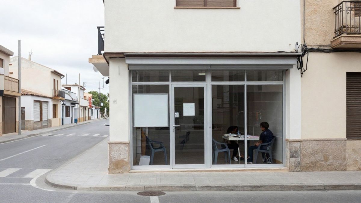Imagen ilustrativa: fachada genérica de un centro cívico municipal con tablón de anuncios y sillas en la entrada