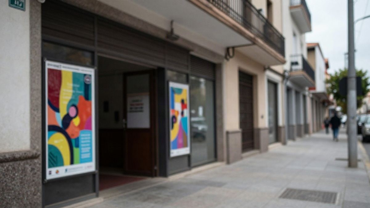 Imagen ilustrativa: entrada de un centro cívico con tablón de anuncios y carteles abstractos, sin personas