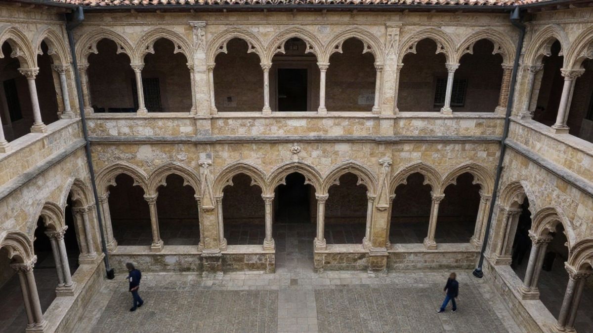 Imagen ilustrativa: vista cenital de un claustro histórico con capiteles góticos y arcos de piedra