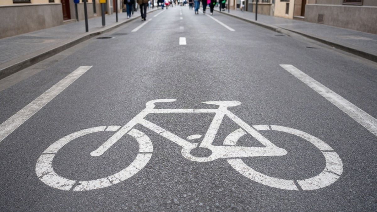 Imagen ilustrativa: detalle de asfalto con marcas de carril bici en una calle corriente
