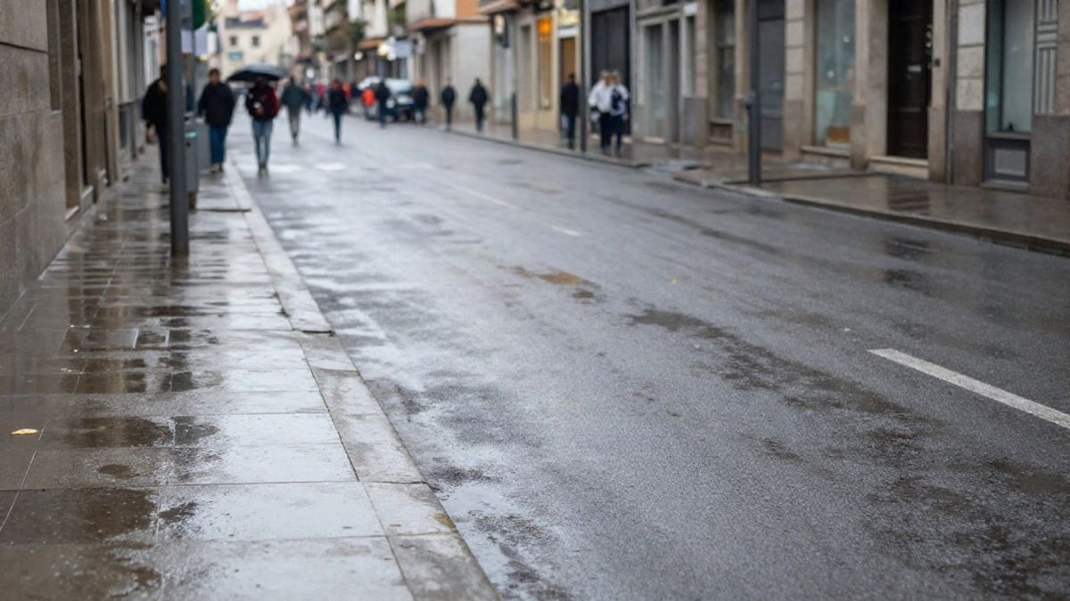 Imagen ilustrativa: calle urbana mojada tras la lluvia, con charcos y edificios en perspectiva