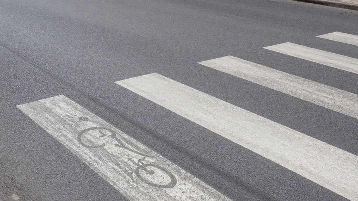 Imagen ilustrativa: detalle del asfalto de una carretera con marcas viales desgastadas y huella de bicicleta