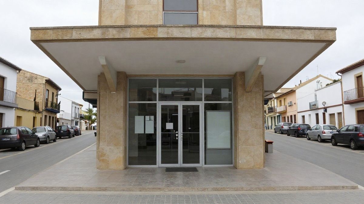 Imagen ilustrativa: fachada de un centro cívico con puertas de cristal y tablón de anuncios en una calle tranquila