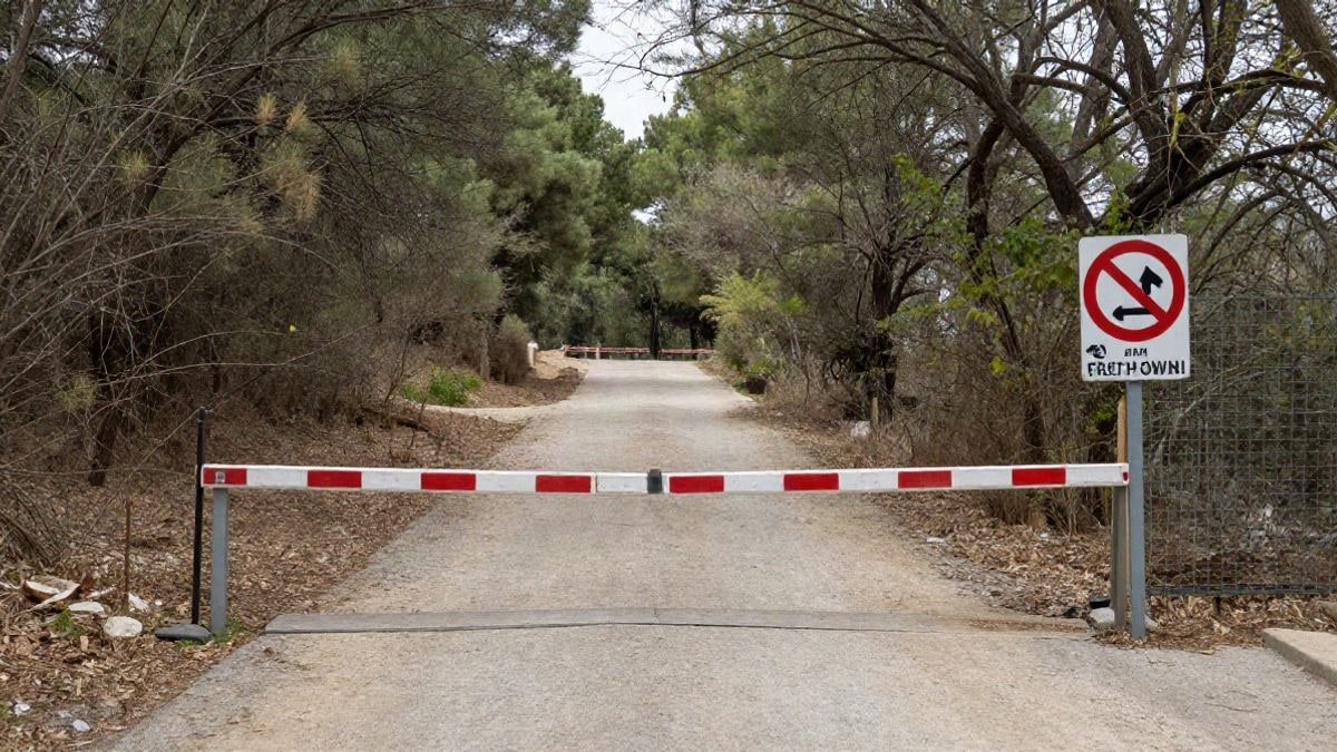 Imagen ilustrativa: sendero forestal con una valla de acceso restringido en un parque mediterráneo