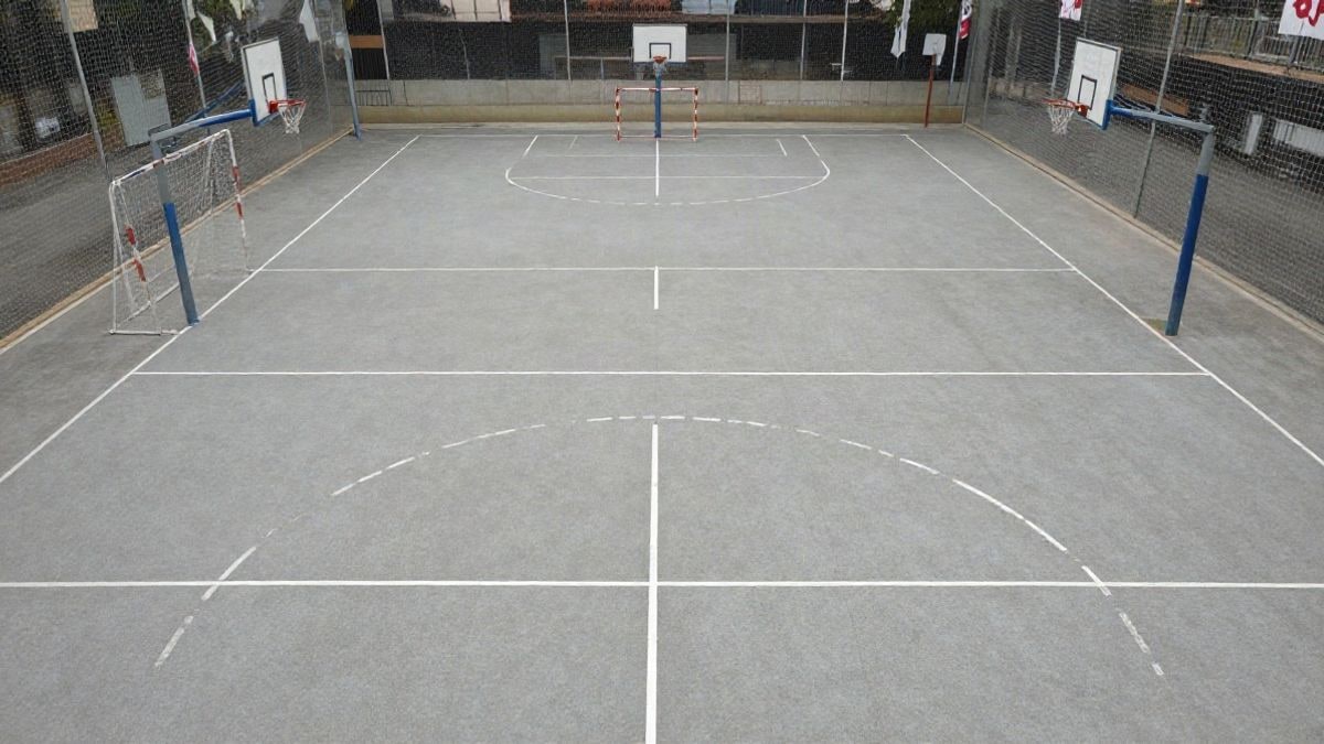Imagen ilustrativa: pabellón deportivo vacío con líneas de pista y porterías de balonmano