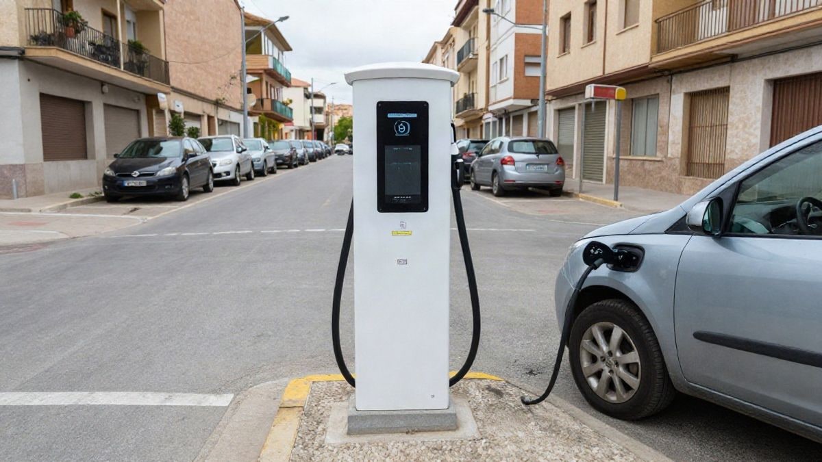 Imagen ilustrativa: un punto de recarga eléctrica público en una calle de Rubí, con un coche enchufado y edificios de fondo.