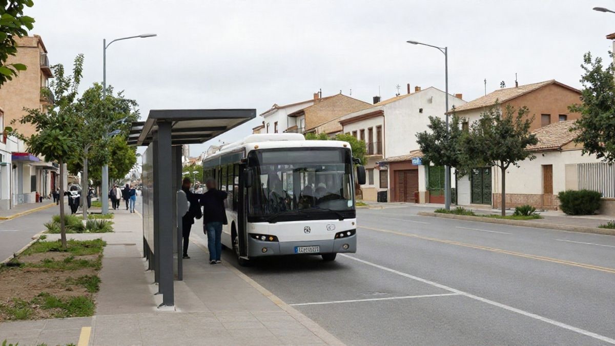 Imagen ilustrativa: un autobús interurbano detenido en una parada de una avenida con árboles y edificios de baja altura.