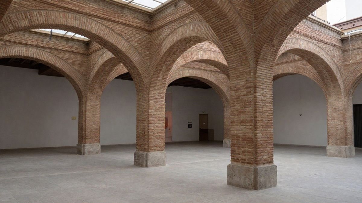 Imagen ilustrativa: interior de un espacio cultural con arcos de ladrillo y bóvedas de cerámica, iluminado por luz natural.