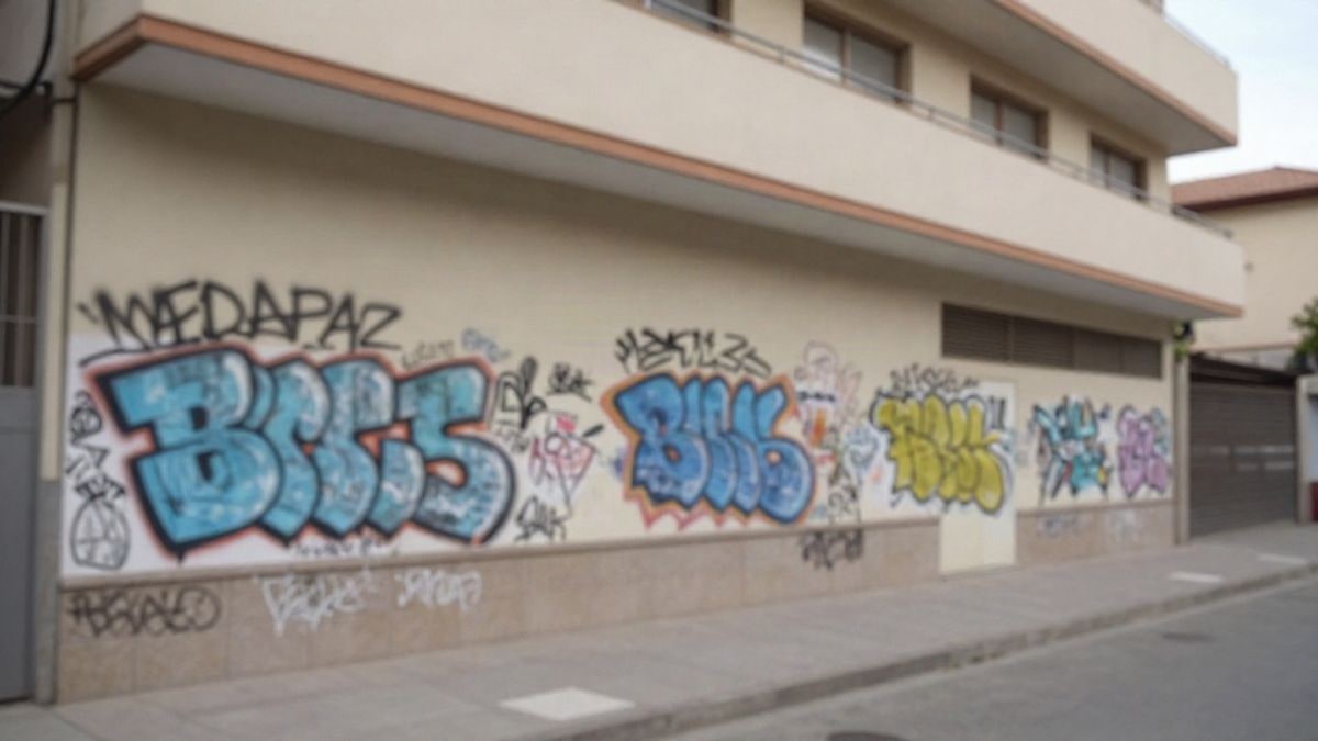 Imagen ilustrativa: fachada de un edificio escolar con una pared cubierta de pintadas