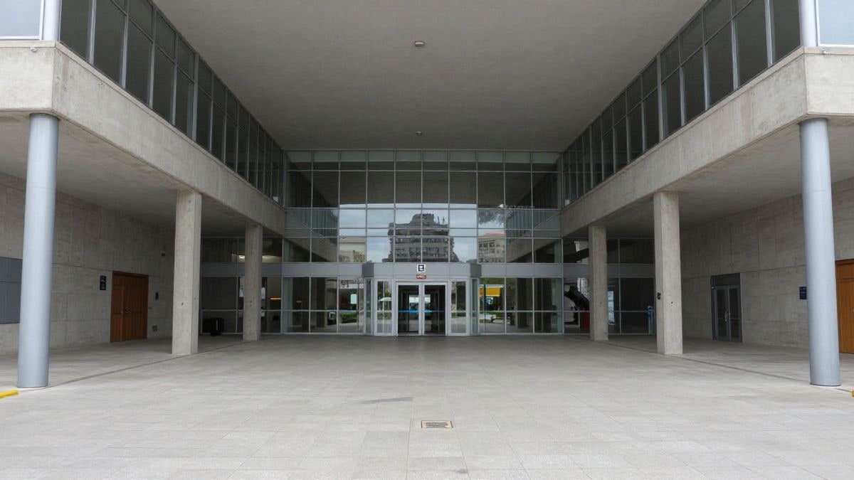 Imagen ilustrativa: auditorio moderno de un campus universitario con líneas arquitectónicas que convergen