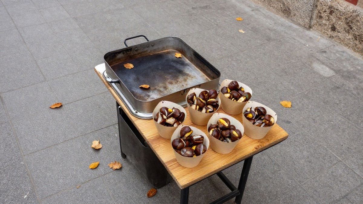 Imagen ilustrativa: puesto callejero de castañas asadas visto desde arriba sobre una mesa de madera
