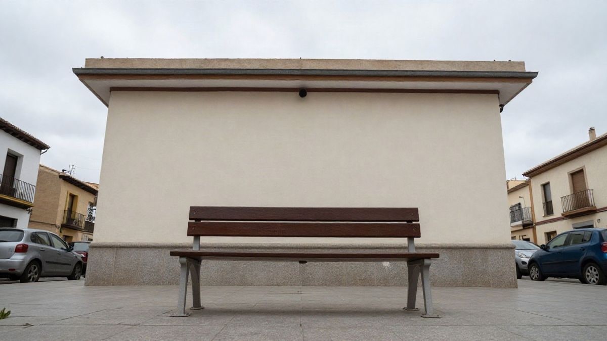Imagen ilustrativa: fachada de un edificio municipal con un banco vacío en la acera