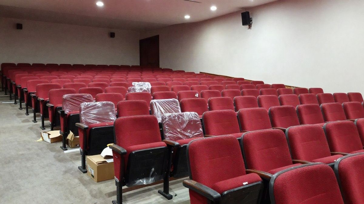 Imagen ilustrativa: filas de butacas rojas vacías en un auditorio, algunas aún con plásticos protectores y cajas en el suelo