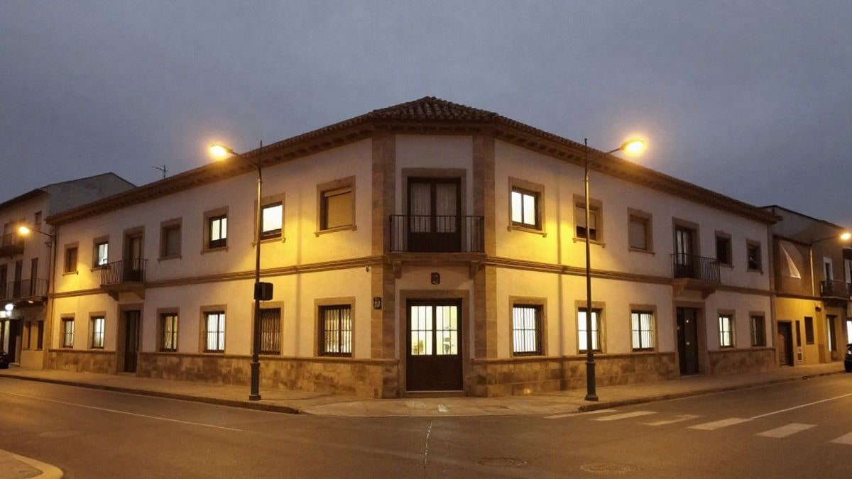 Imagen ilustrativa: fachada de un centro cultural genérico iluminada por farolas y luces interiores al anochecer