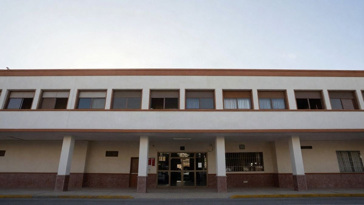Imagen ilustrativa: ángulo bajo de la fachada de un edificio escolar genérico con cielo despejado