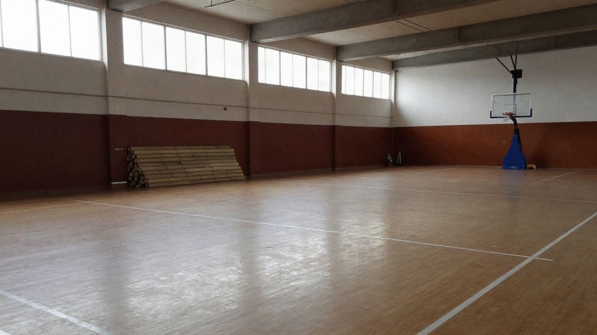 Imagen ilustrativa: interior de un pabellón deportivo municipal con pavimento de PVC y líneas de juego pintadas