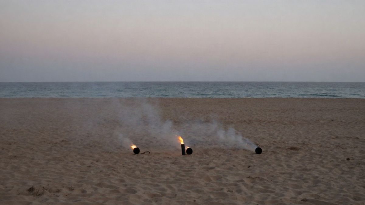 Imagen ilustrativa: playa urbana con material pirotécnico preparado para un espectáculo de fuegos artificiales al atardecer