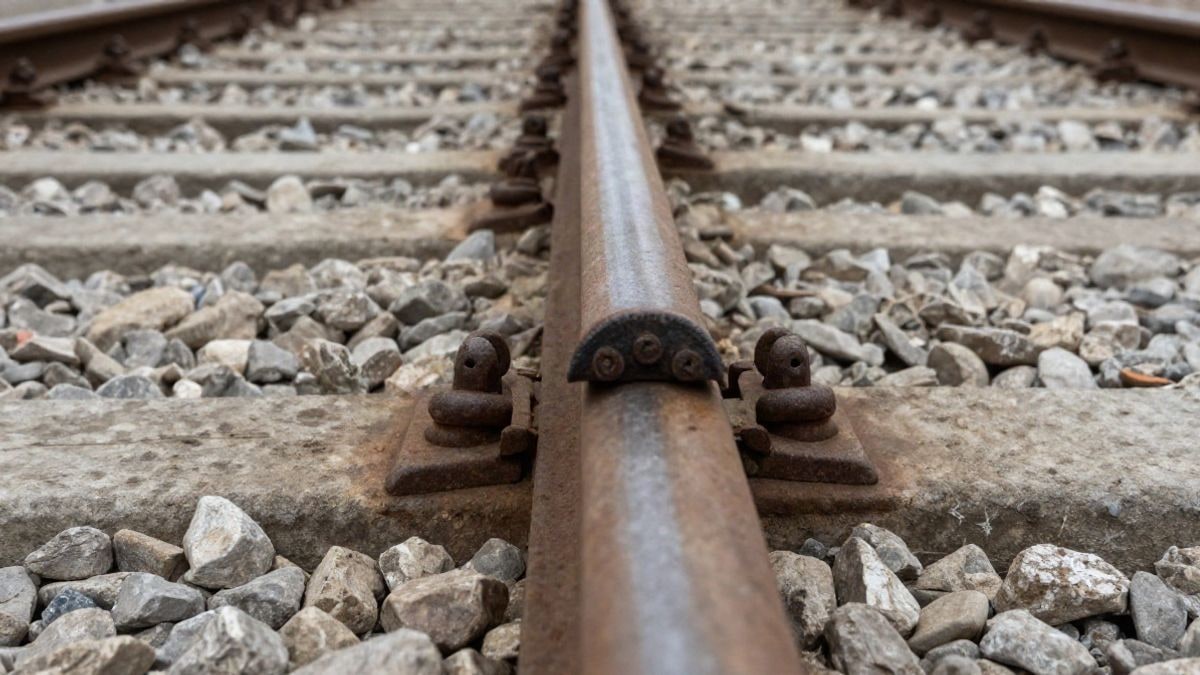 Imagen ilustrativa: primer plano de balasto ferroviario y un tornillo de vía oxidado