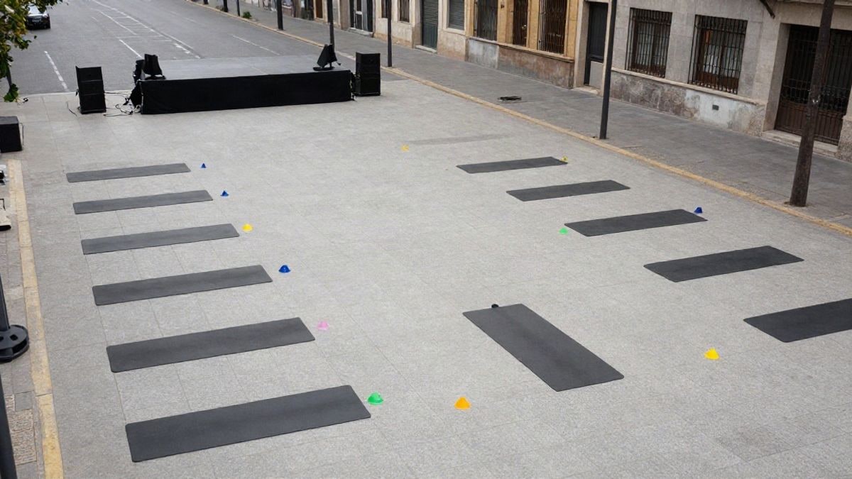 Imagen ilustrativa: vista cenital de una zona de clase de fitness al aire libre con esterillas y conos en una avenida urbana