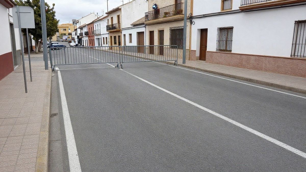 Imagen ilustrativa: un pequeño aparcamiento urbano recién asfaltado con plazas pintadas y una barrera de entrada en una calle residencial.