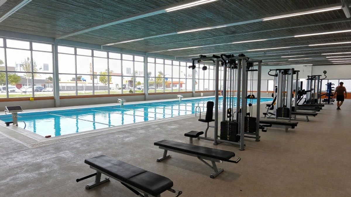 Imagen ilustrativa: interior de un centro deportivo municipal con piscina y zona de fitness, sin personas.