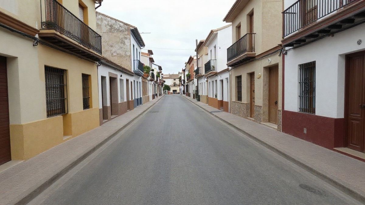 Imagen ilustrativa: calle residencial con líneas convergentes de asfalto y aceras en un día nublado