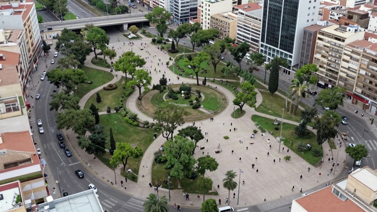 Imagen ilustrativa: vista de un parque urbano con árboles y caminos, rodeado de edificios, en un día nublado.