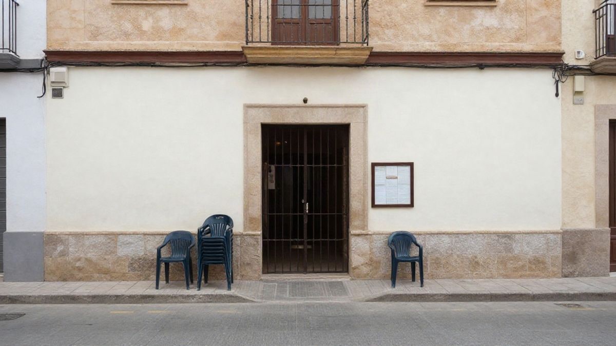 Imagen ilustrativa: entrada genérica de un local municipal con sillas apiladas junto a la puerta