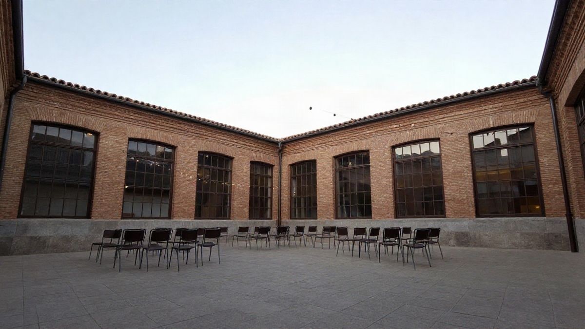 Imagen ilustrativa: patio de un antiguo edificio municipal con sillas preparadas para un acto al aire libre