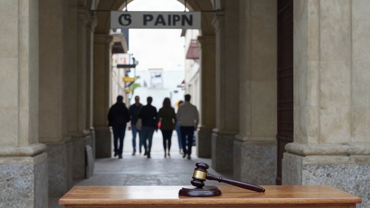Imagen ilustrativa: pasillo de un juzgado con bancos y una puerta de sala de vistas