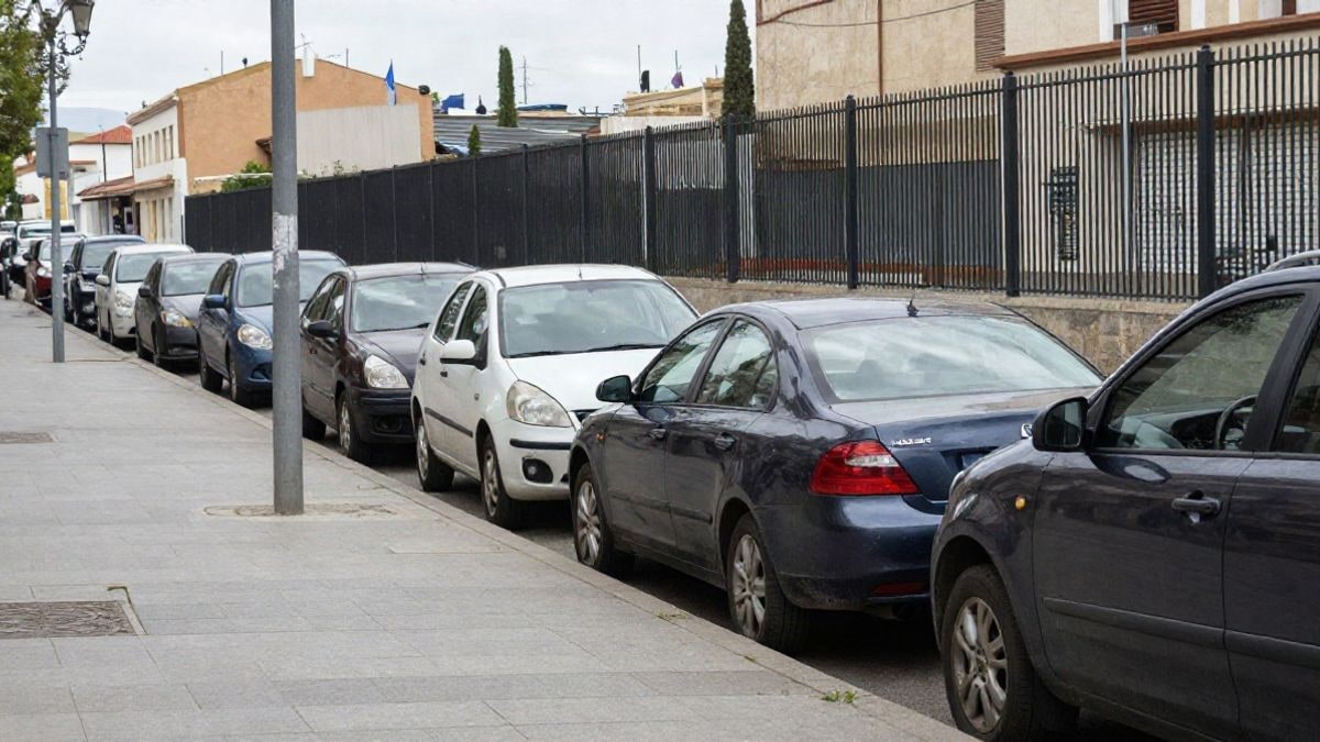 Imagen ilustrativa: varios patinetes eléctricos aparcados en fila junto a una valla metálica en una calle de ciudad.