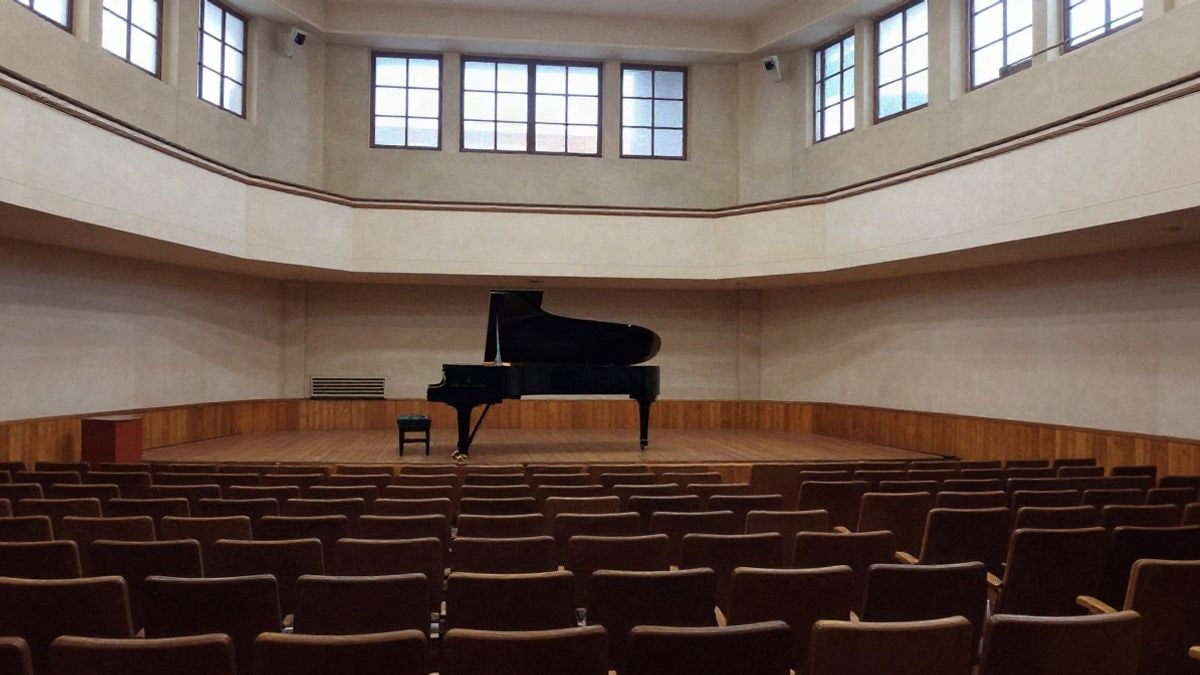 Imagen ilustrativa: sala de conciertos pequeña con butacas vacías y un piano de cola en el escenario