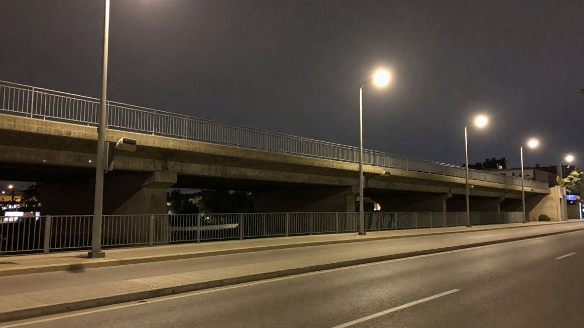 Imagen ilustrativa: puente urbano genérico de noche con luces artificiales y barandillas metálicas