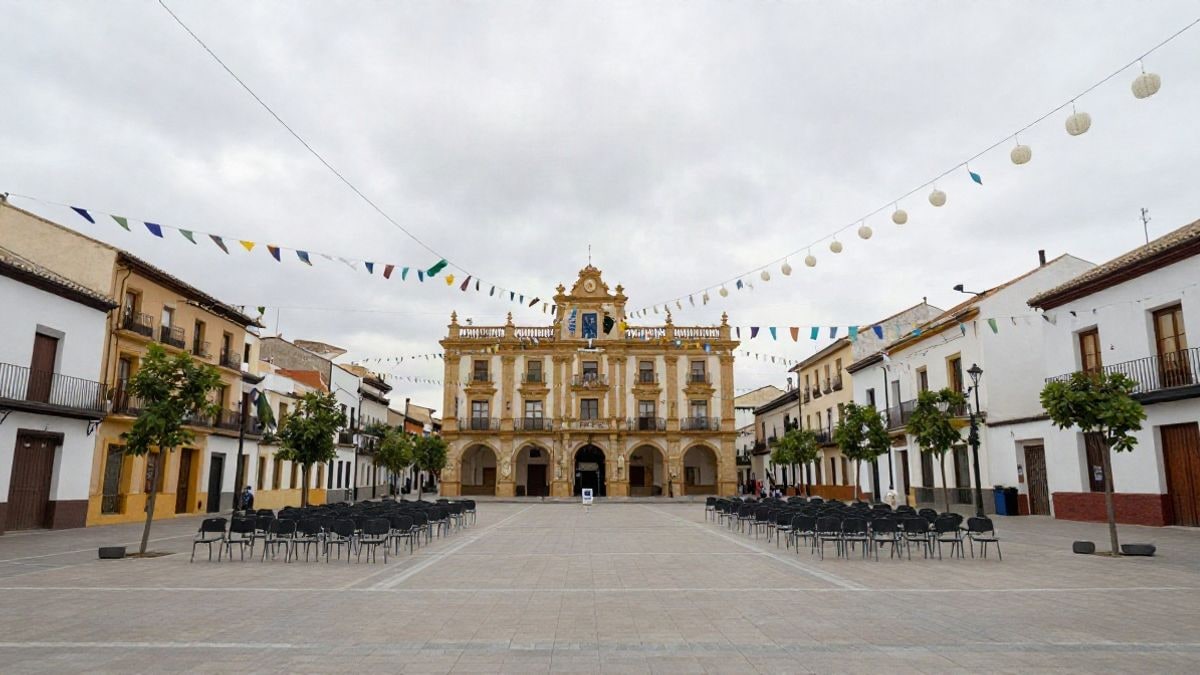 Imagen ilustrativa: plaza de un municipio con guirnaldas y sillas preparadas para un acto festivo