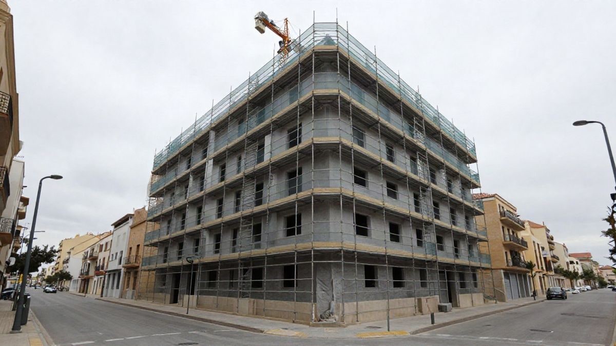 Imagen ilustrativa: edificio residencial en construcción con andamios y grúa, visto en un gran angular con líneas convergentes