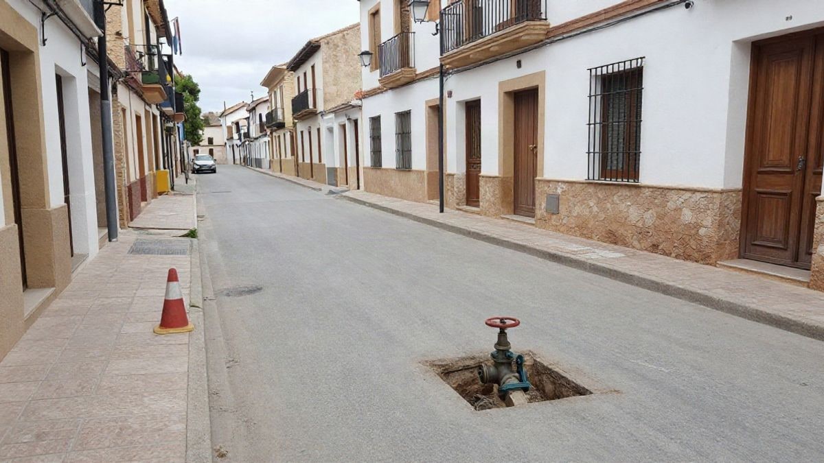 Imagen ilustrativa: calle con obras de reparación de la red de agua en un municipio español, con conos y una zanja en la acera.