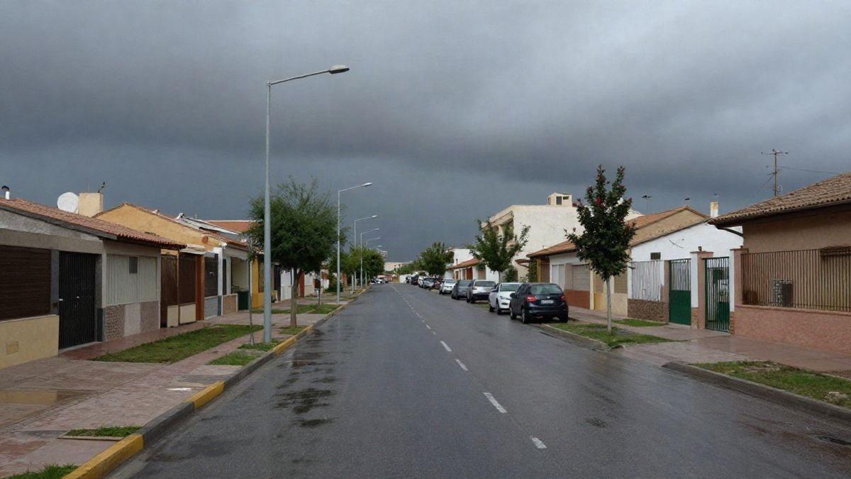 Imagen ilustrativa: calle urbana mojada bajo un cielo encapotado, con líneas de farolas y edificios bajos al fondo