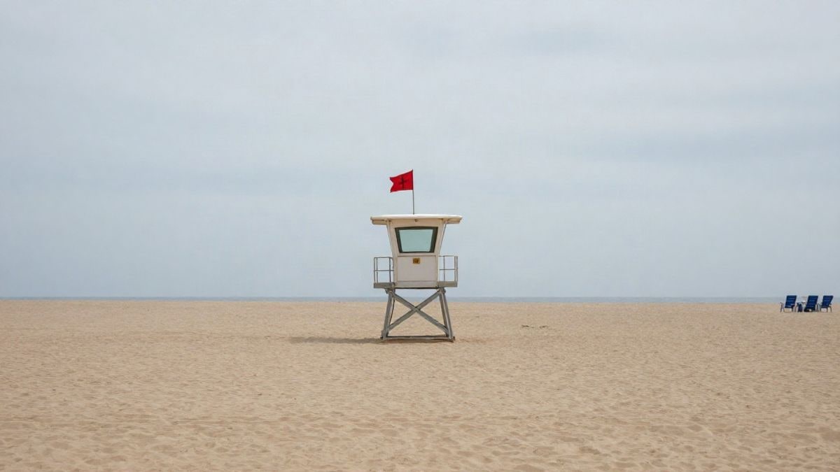 Imagen ilustrativa: torre de vigilancia de socorrismo en una playa vacía con bandera roja ondeando