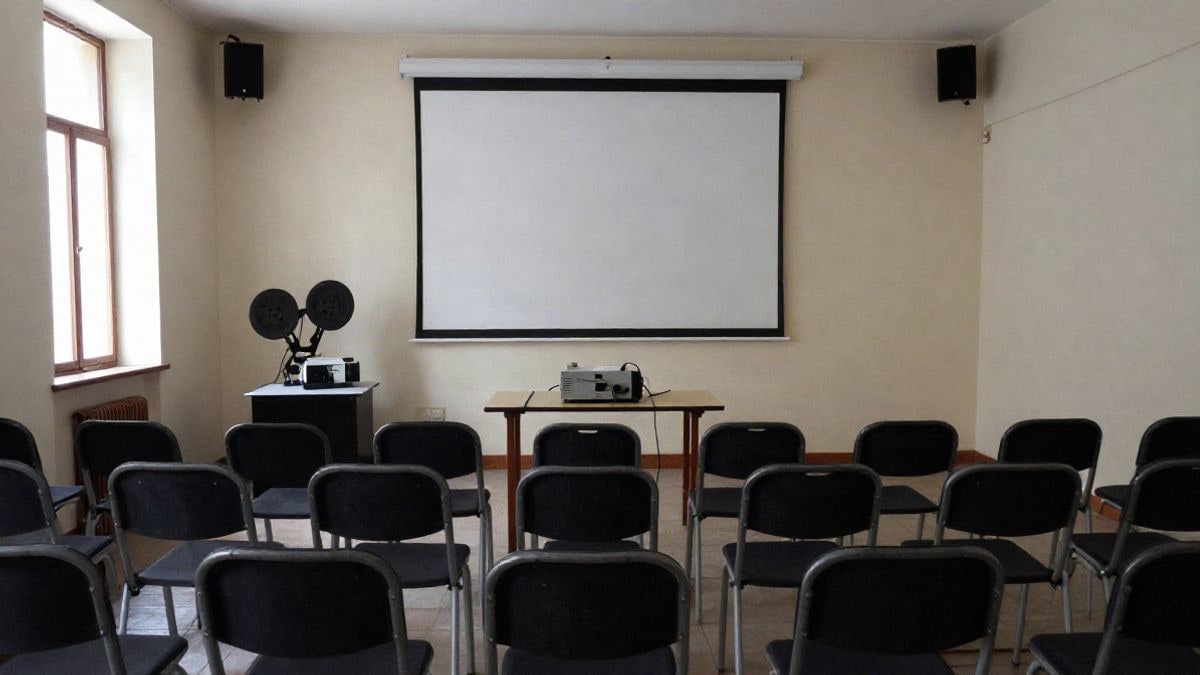 Imagen ilustrativa: interior de un auditorio municipal con sillas plegables vacías frente a una pantalla de proyección