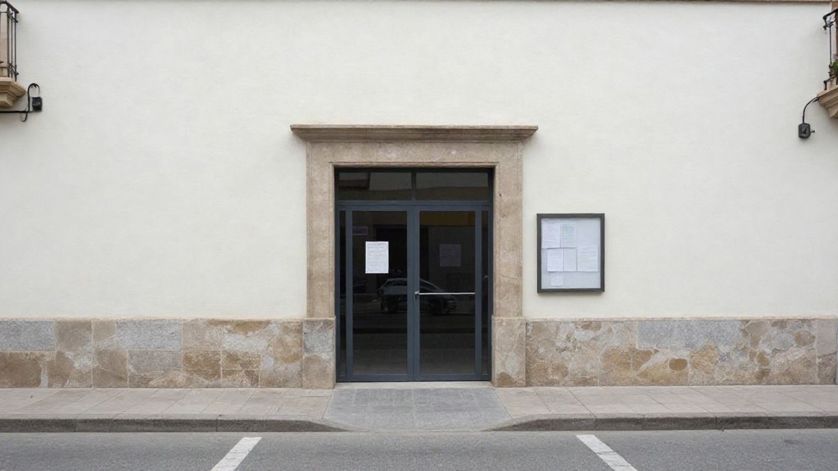Imagen ilustrativa: fachada de un centro juvenil municipal con puerta de cristal y tablón de anuncios en una calle corriente