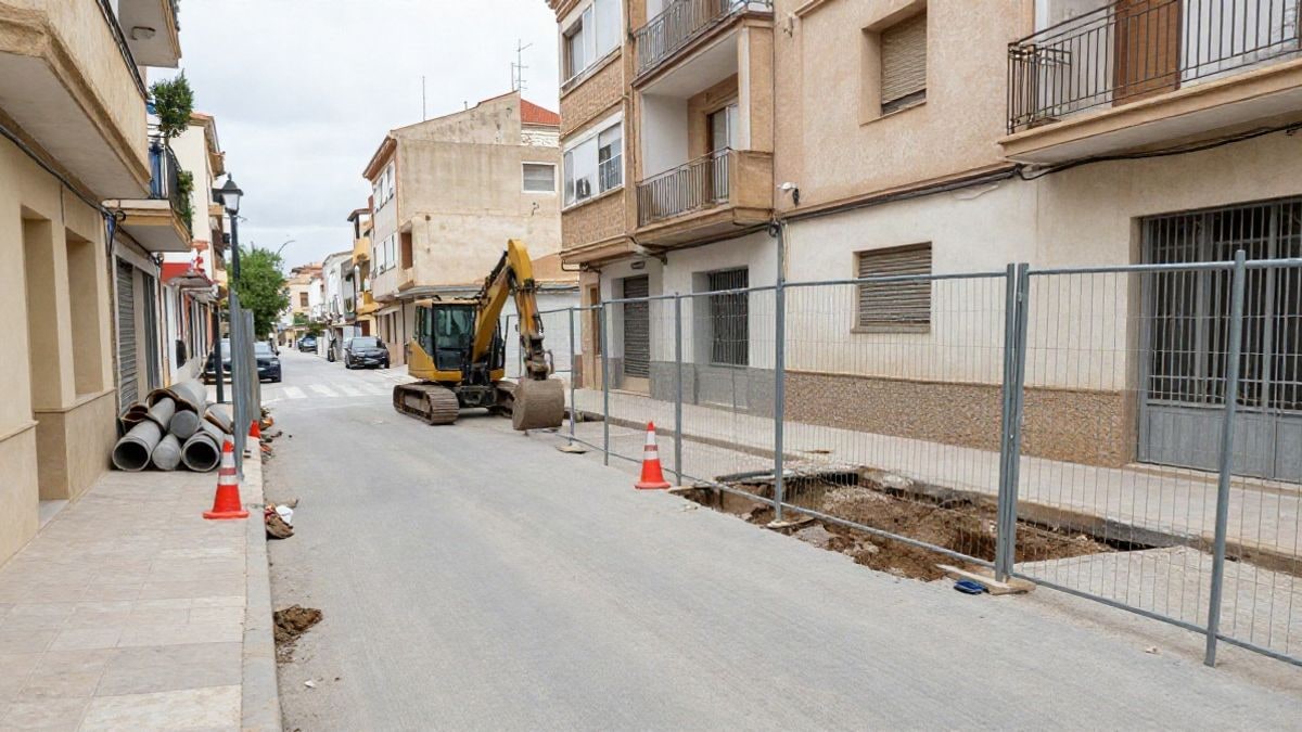 Imagen ilustrativa: calle residencial en obras con vallas, conos y tuberías junto a fachadas de viviendas
