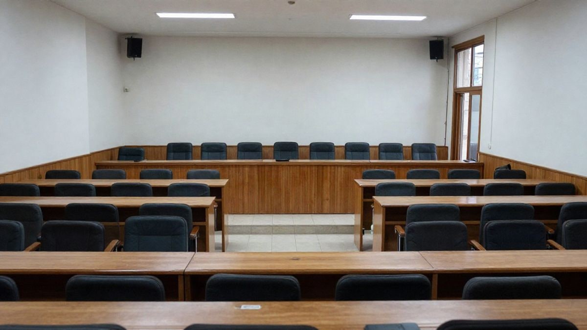 Imagen ilustrativa: sala de plenos genérica con asientos vacíos y una persona al fondo