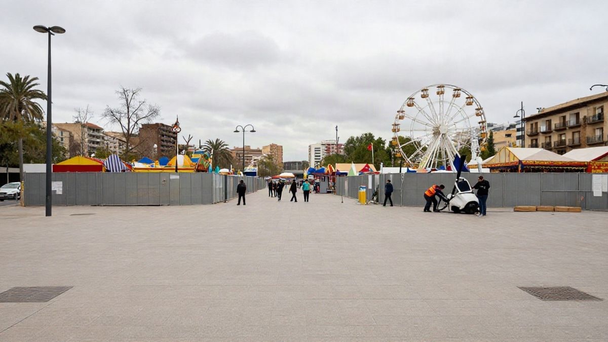 Imagen ilustrativa: un paseo con algunas atracciones de feria y vallas de obra bajo un cielo nublado