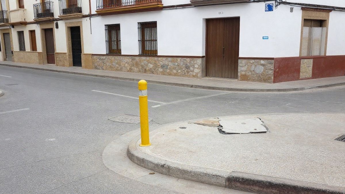 Imagen ilustrativa: una calle con una pilona amarilla recién instalada junto a una acera reparada