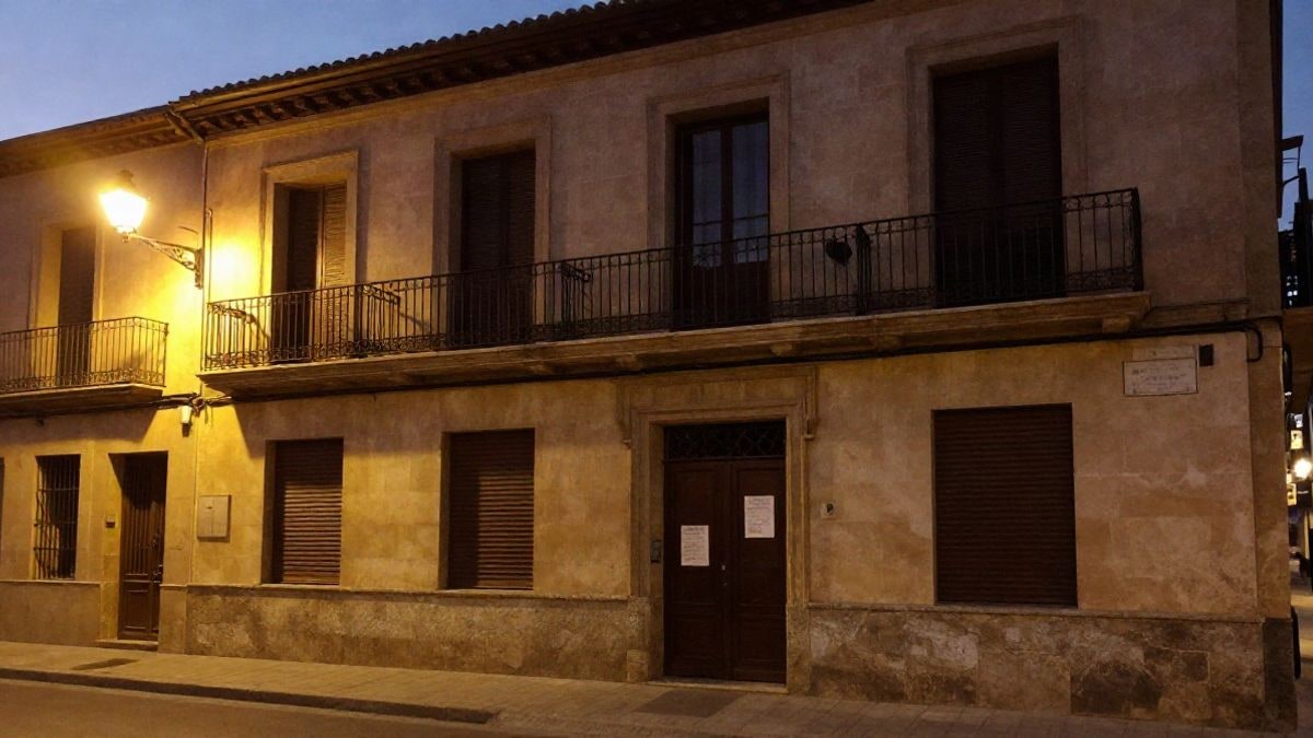 Imagen ilustrativa: fachada de un edificio consistorial de noche con un aviso en la puerta